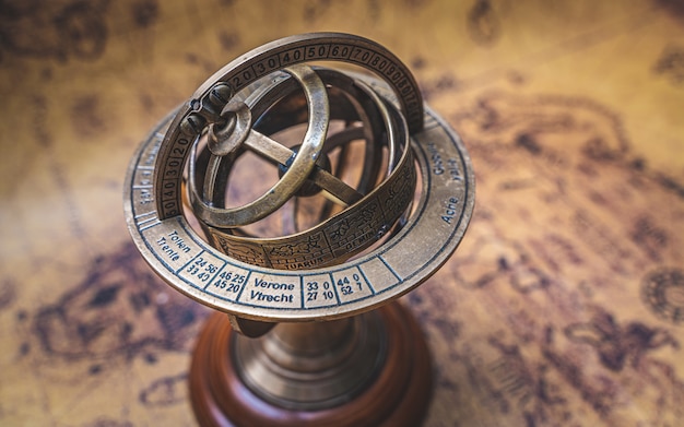 Foto esfera de reloj de sol armillary de bronce vintage con signo del zodiaco