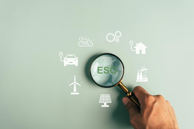 ESG Ambiental, ambiental, social y de gobernanza en negocios sostenibles y éticos en la conexión de red. La lupa se enfoca en el icono ESG de la Tierra para desarrollar el concepto de energía verde.