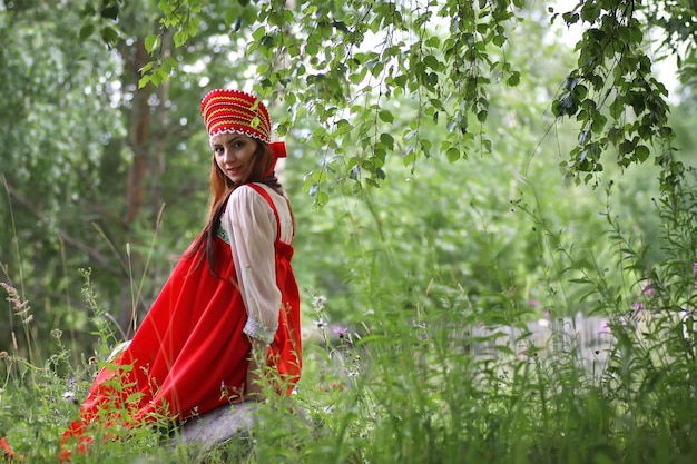 Eslavo en traje tradicional está sentado en la naturaleza