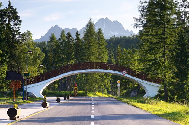 ESLOVAQUIA, SHTRBSVE PLESO - 29 DE JUNIO: paisaje de verano con carretera en un resort de montaña y un puente peatonal. Tatras, Eslovaquia