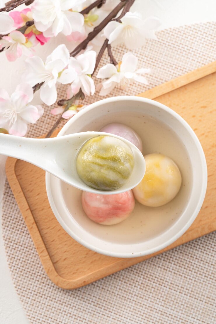 Foto esmalte colorido estilo grande tangyuan com flor de cerejeira e sopa de xarope