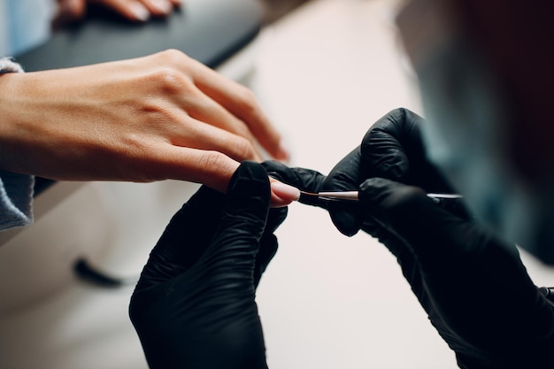 Esmalte de unhas de dedo de mãos femininas de processo de manicure.