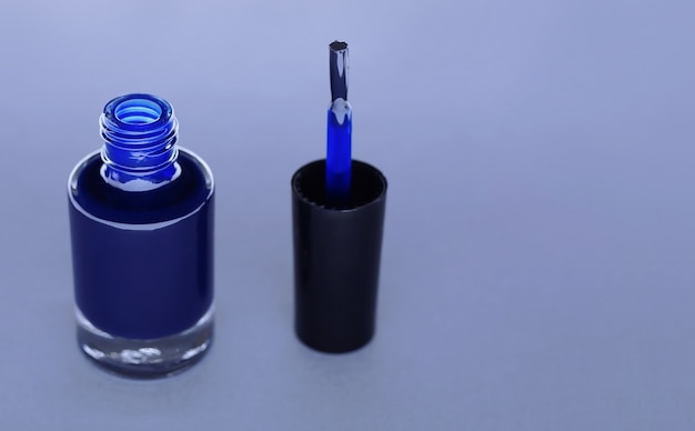 Esmalte de uñas azul sobre fondo gris