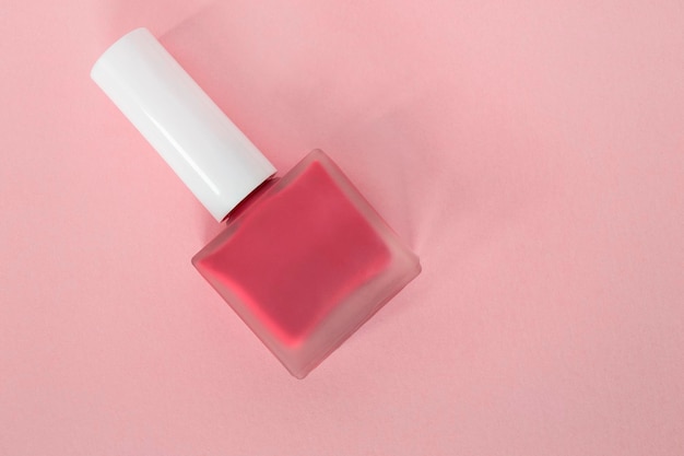 Esmalte de uñas sobre fondo rosa