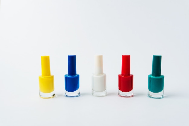 Esmaltes de uñas de colores sobre un fondo blanco.