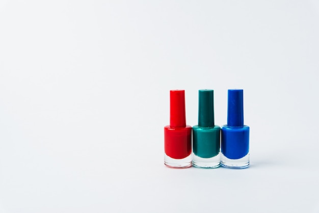Esmaltes de uñas de colores sobre un fondo blanco.
