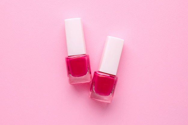 Esmaltes de uñas cosméticos de color rosa sobre rosa