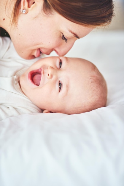 Eso le hace cosquillas a mamá Foto de una joven madre que se une a su adorable bebé en casa