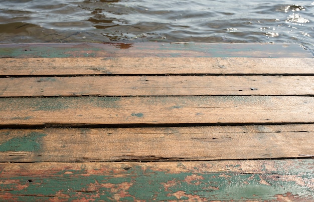 Espacie la tabla de madera vieja en un fondo del paisaje del mar.