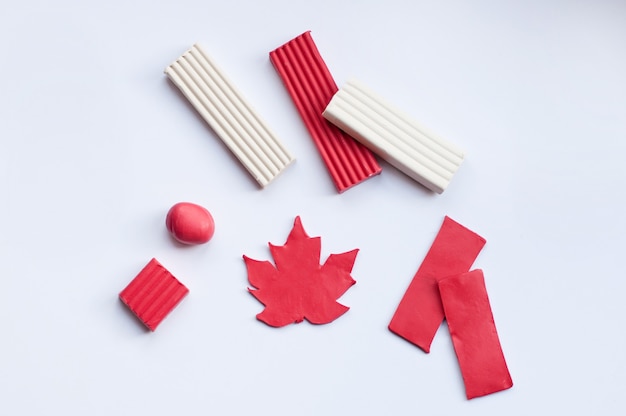 Un espacio en blanco para la artesanía de la bandera de Canadá en forma de hoja roja y tiras con bloques de plastilina