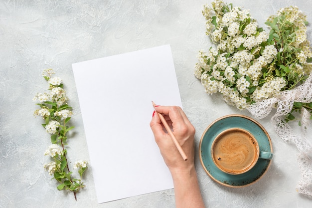 Espacio en blanco para texto, café negro de la mañana y flores de primavera de ramo blanco