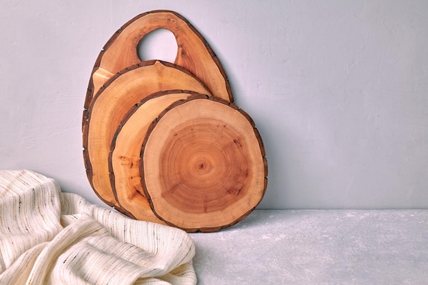 Espacio de cocina con tablas de cortar de madera y paño de cocina sobre una mesa de hormigón ligero para la presentación de alimentos