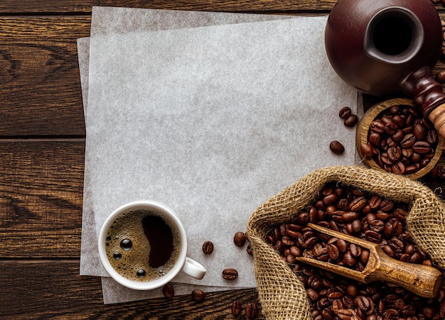 Espacio de copia de hoja de papel en blanco sobre fondo de café rústico con textura de madera aromática recién hecha