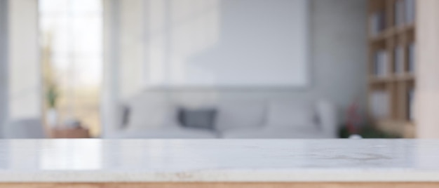 Espacio de maqueta en una mesa de mármol blanco sobre una sala de estar borrosa con un cómodo sofá en el fondo