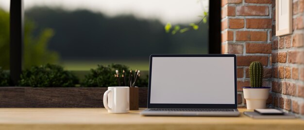 Espacio de trabajo antiguo con portátil portátil y espacio para copiar en una mesa de madera con pared de ladrillo rojo