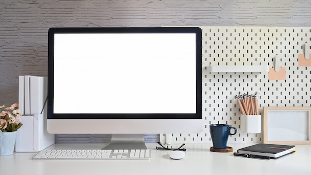 Espacio de trabajo y computadora de escritorio con pantalla en blanco