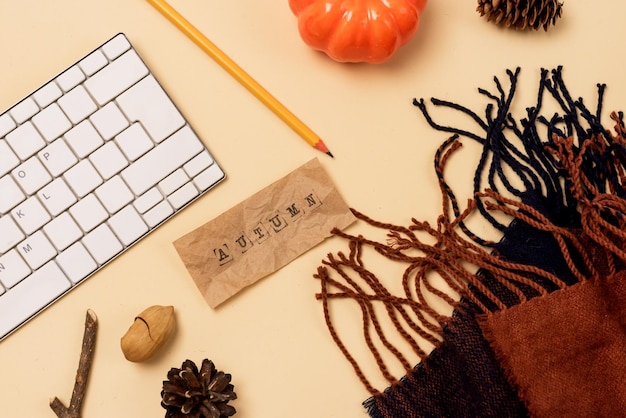 Espacio de trabajo con computadora portátil o teclado Lápiz Pañuelo acogedor y cálido CalabazaPiña de pino y taza de café