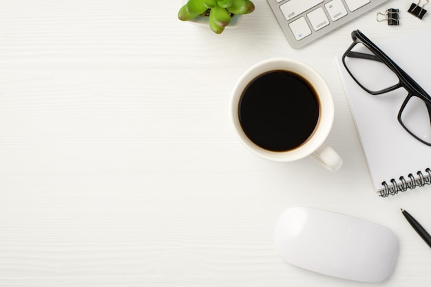 Espacio de trabajo del concepto de trabajador profesional serio. Por encima de la sobrecarga, vista de cerca, gafas con teclado en espiral, taza de ratón de bebida, fondo blanco de madera aislado