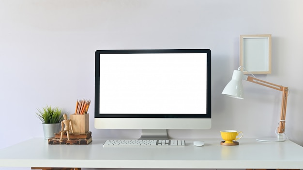 Espacio de trabajo creativo con computadoras y suministros de oficina en la mesa.