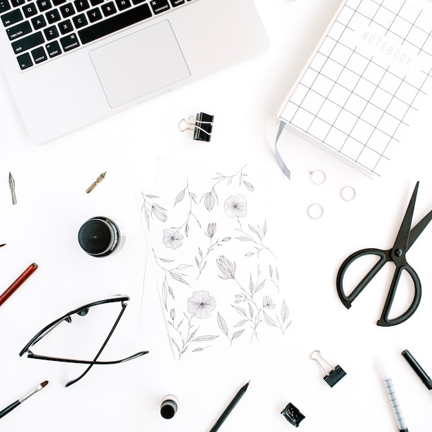 Foto espacio de trabajo con cuaderno, portátil, tijeras, gafas, bolígrafo en blanco.