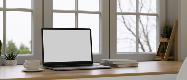 Espacio de trabajo de diseño de interiores escandinavo cerca de la ventana renderizado 3d de maqueta de pantalla en blanco portátil