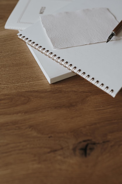 Espacio de trabajo elegante estético con tarjeta de hoja de papel en blanco de cuaderno sobre mesa de fondo de madera Concepto de arte de caligrafía