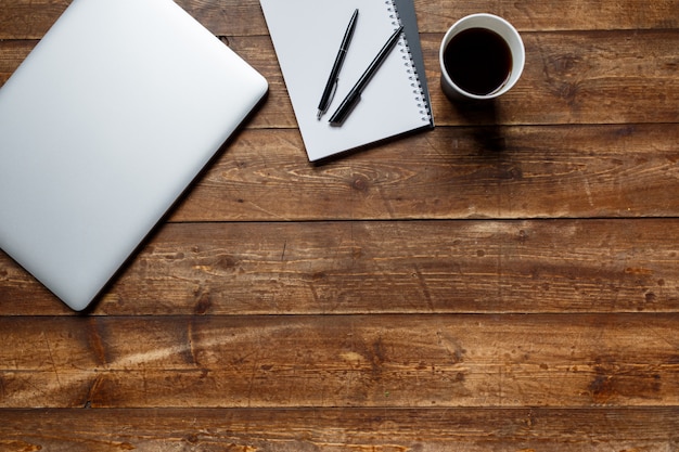 Espacio de trabajo de un empresario. vista desde arriba . portátil de café y portátil en el escritorio con nota negra.