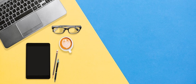 Foto espacio de trabajo de escritorio de oficina colorido con laptop, lentes, tabletas, café con espacio de copia