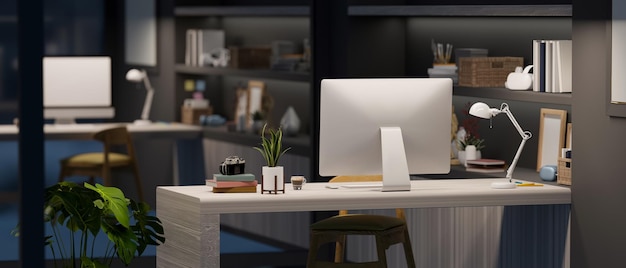 Espacio de trabajo de escritorio de oficina por la noche en un estilo interior moderno con computadora y accesorios en la mesa