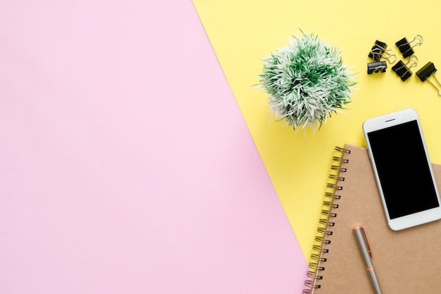 Espacio de trabajo de escritorio de oficina - vista superior plana del espacio de trabajo con el cuaderno blanco en blanco