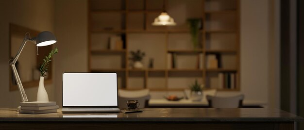 Espacio de trabajo con lámpara de mesa de maqueta de computadora portátil y decoración en la mesa sobre fondo borroso