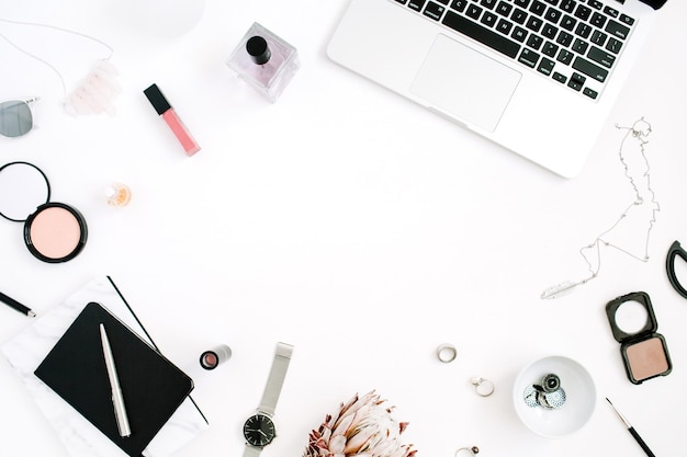 Espacio de trabajo de marco de blogger o freelancer con portátil de flores protea y accesorios femeninos sobre fondo blanco Escritorio de oficina en casa con vista superior plana