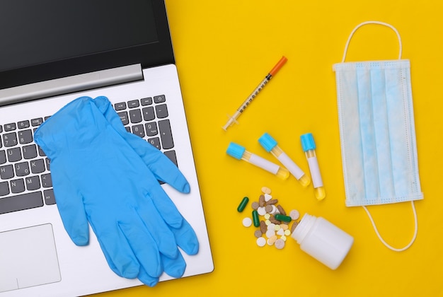 Espacio de trabajo del médico con portátil sobre un fondo amarillo. Vista superior. Endecha plana