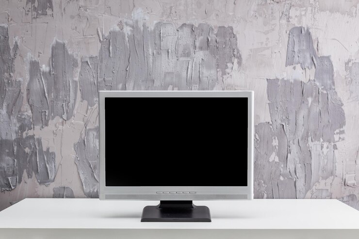 Foto espacio de trabajo minimalista moderno con un monitor de computadora en blanco contra una pared gris texturizada