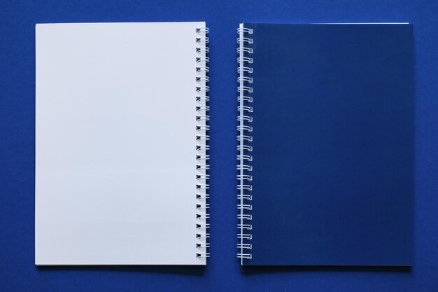 Espacio de trabajo mínimo con diseño de cuaderno azul y papelería sobre fondo azul Concepto de oficina