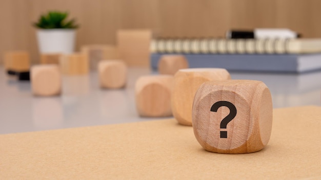 Un espacio de trabajo moderno con bloques de madera con un signo de interrogación que simboliza la investigación y la creatividad