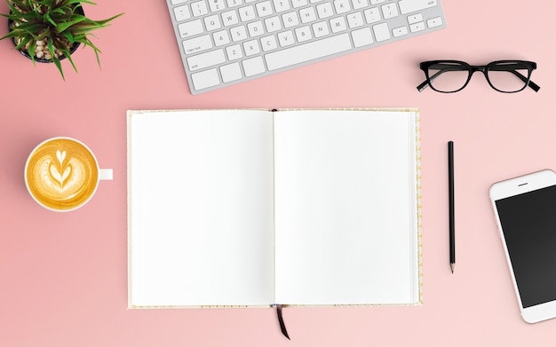 Foto espacio de trabajo moderno con taza de café, teclado, teléfono inteligente y computadora portátil en color rosa