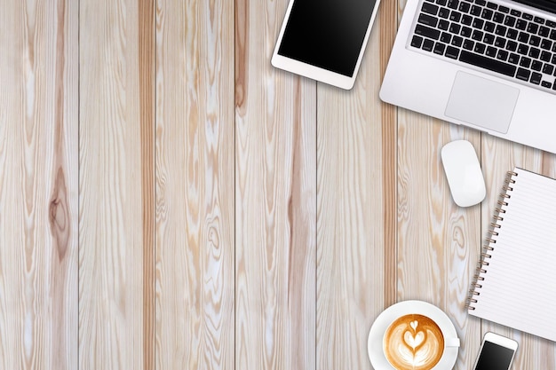 Espacio de trabajo moderno con teléfono inteligente de tableta portátil y espacio de copia de taza de café sobre fondo de madera