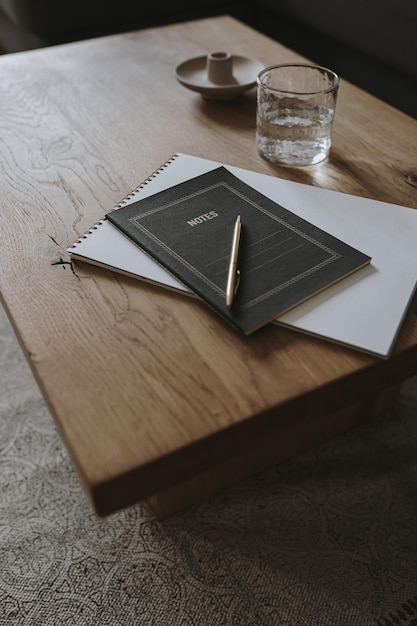 Espacio de trabajo de oficina en casa Elegante trabajo independiente Lugar de trabajo de negocios Cuaderno vaso de agua pluma de hierba seca