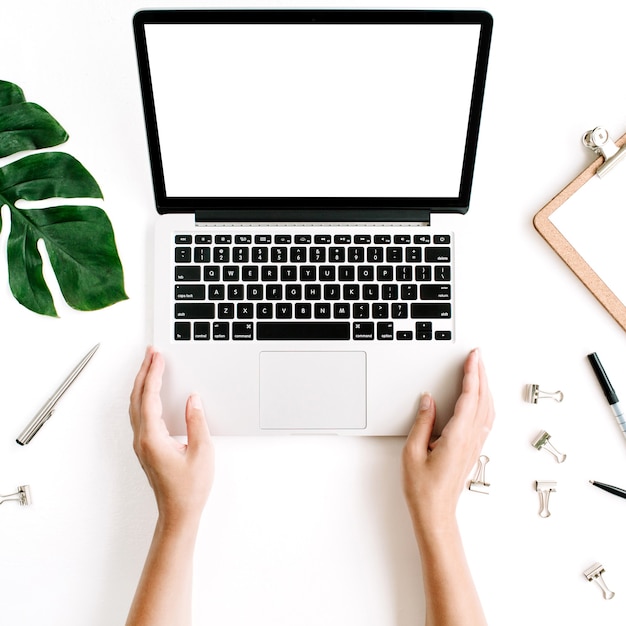 Espacio de trabajo de la oficina en casa con las manos trabajando en el teclado de la computadora portátil