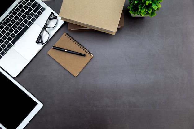 Espacio de trabajo en la oficina, escritorio blanco de madera con cuaderno en blanco y otros suministros de oficina