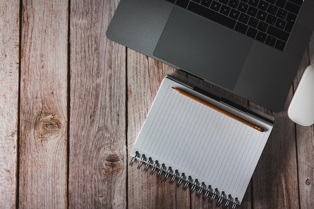 Espacio de trabajo con portátil y lápiz sobre fondo de madera Vista superior Espacio de copia Enfoque selectivo