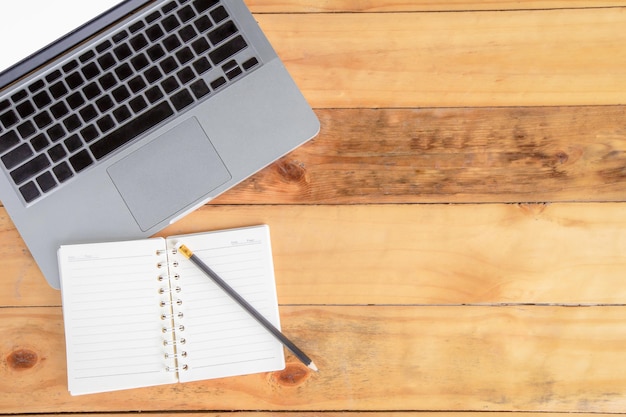 Espacio de trabajo con portátil y lápiz sobre mesa de madera