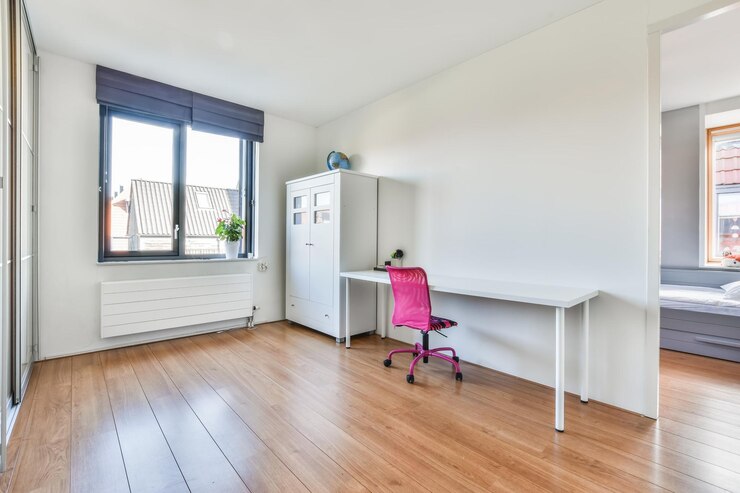 Un espacio de trabajo con una silla rosa.