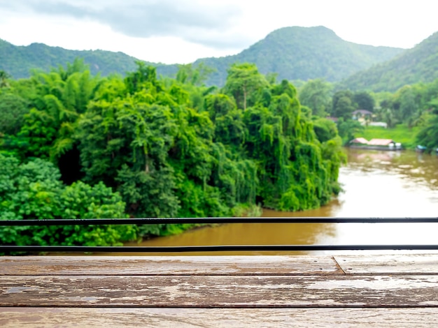 Espacio vacío en la vieja barra de mesa de tablones de madera en el bosque tropical verde salvaje del río y vista a la montaña