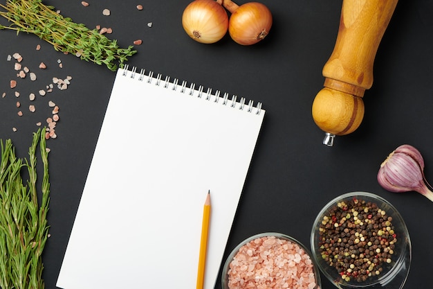 Espacios, condimentos y papel de cuaderno en blanco con lápiz. Maqueta de papel de cuaderno para recibo de comida, menú o concepto de blog de comida. Vista superior