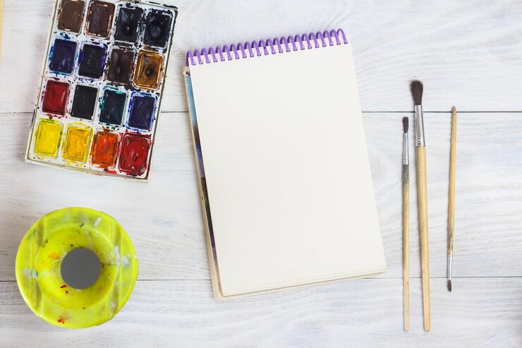 Foto espaço criativo o espaço de trabalho do artista na mesa surrada pintar pincéis de caderno em aquarela
