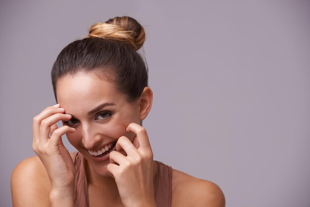 Foto espaço de retrato ou mulher feliz rindo com beleza natural em estúdio com piada engraçada com maquete cuidados com a pele do rosto ou modelo feminino desfrutando de comédia ou humor em fundo roxo com sorriso ou bem-estar