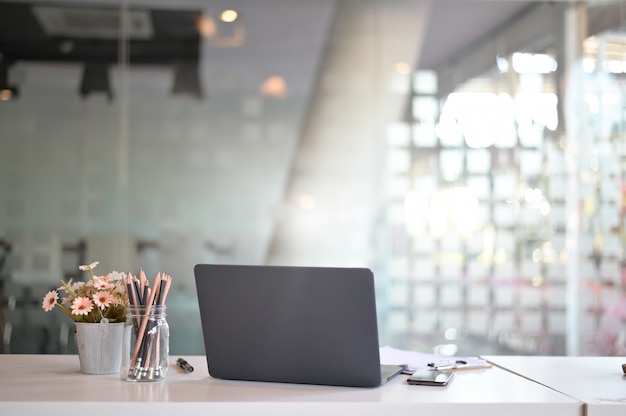 Espaço de trabalho à moda com laptop, materiais de escritório, flor no escritório. conceito de trabalho de mesa.