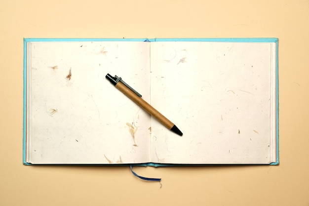 Espaço de trabalho com caneta e caderno em um fundo amarelo. postura plana
